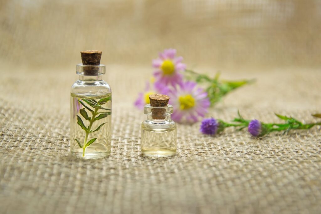 Two small glass bottles of herbal oil with flowers